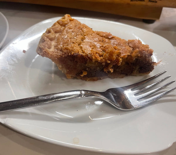 a slice of chocolate chip pie on a plate with a fork ready to eat