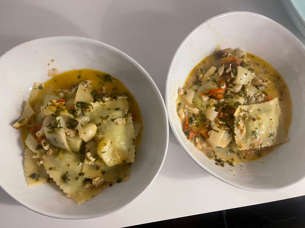 2 bowls of ravioli with vegetable sauce
