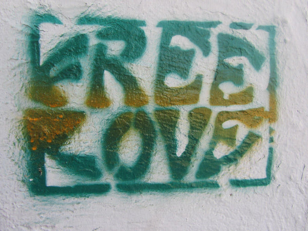 An outdoor wall, with the words "Free Love" spray painted in block letters.